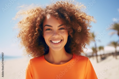 A woman with curly hair smiling at the camera. Perfect for lifestyle and beauty concepts