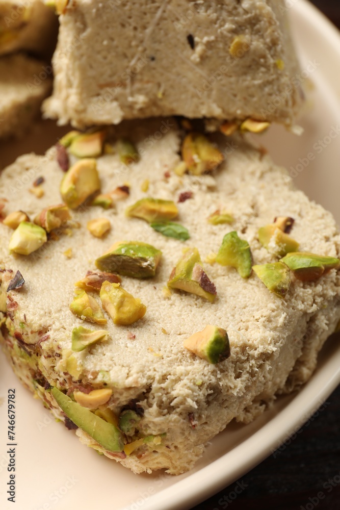 Pieces of tasty halva with pistachios on table, closeup Pieces of tasty halva with pistachios on table, closeup