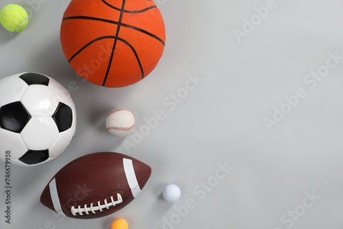 Many different sports balls on gray background, flat lay. Space for text
