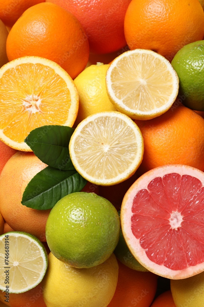 Different fresh citrus fruits and leaves as background, top view Different fresh citrus fruits and leaves as background, top view