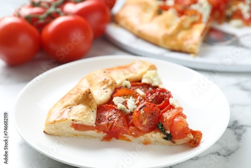Tasty galette with tomato and cheese (Caprese galette) on white marble table, closeup