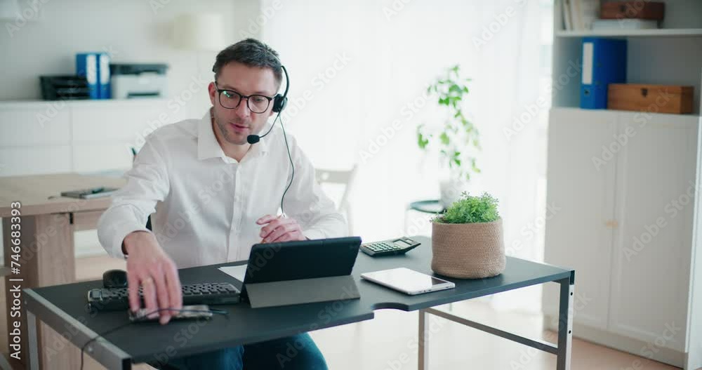 Young businessman talking through headset in office Young businessman talking through headset in office