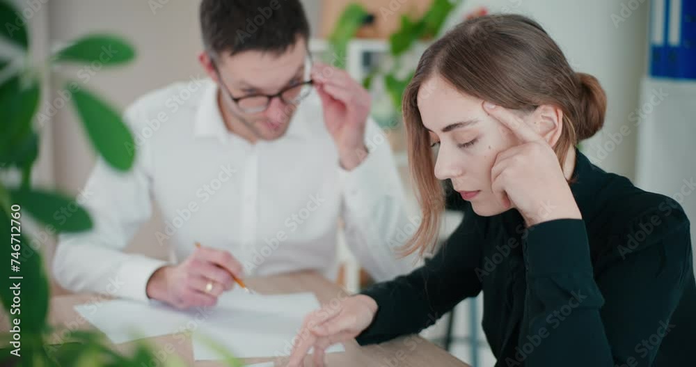 Stressed young businesswoman calculating budget Stressed young businesswoman calculating budget