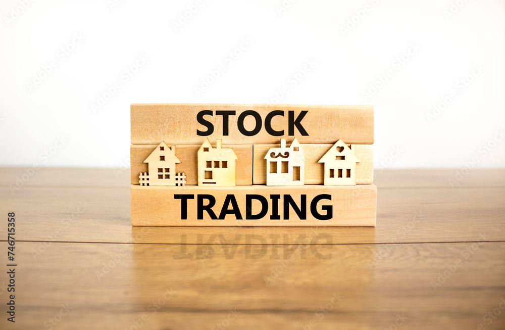 Stock trading symbol. Concept words Stock trading on beautiful wooden blocks. Beautiful wooden table white background. House model. Business stock trading concept. Copy space. Stock trading symbol. Concept words Stock trading on beautiful wooden blocks. Beautiful wooden table white background. House model. Business stock trading concept. Copy space.