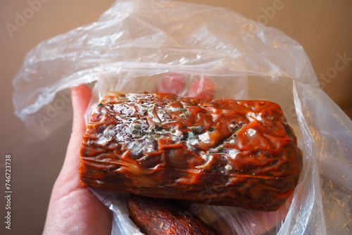 Raw smoked sausage became moldy while it was in a plastic bag. A mold or mould. The dust-like, colored appearance of molds is due to the formation of spores containing fungal secondary metabolites. photo