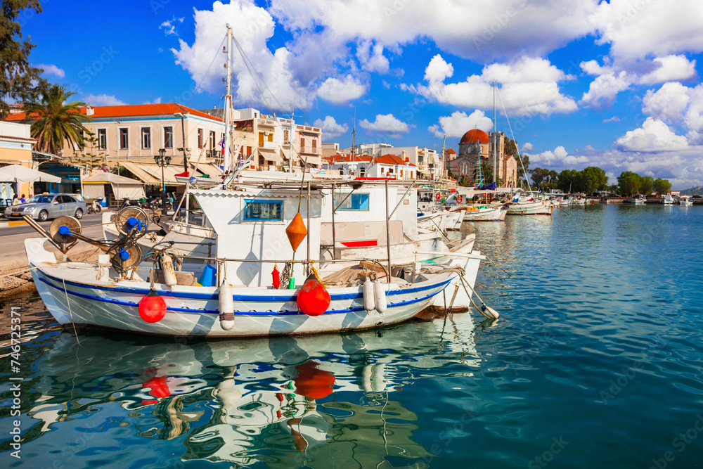 Saronics islands of Greece . Charming beautiful Greek island -Aegina with traditional fishing boats and St. Nicholas Church.