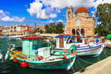 Saronics islands of Greece . charming beautiful Greek island -Aegina with traditional fishing boats and St. Nicholas Church.