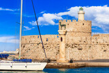 Greece travel, Dodecanese. Rhodes island. Mandraki Harbor with symbol statue of deer and saillboats
