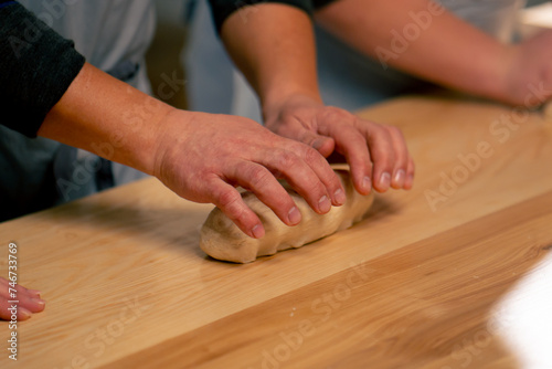 layout in a professional kitchen a group of bakers at the table process the dough and form it into mold