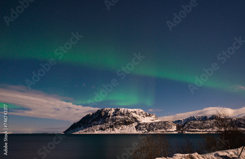 Beautiful green-colored northern lights over a fjord on the Lofoten Islands in Norway photo