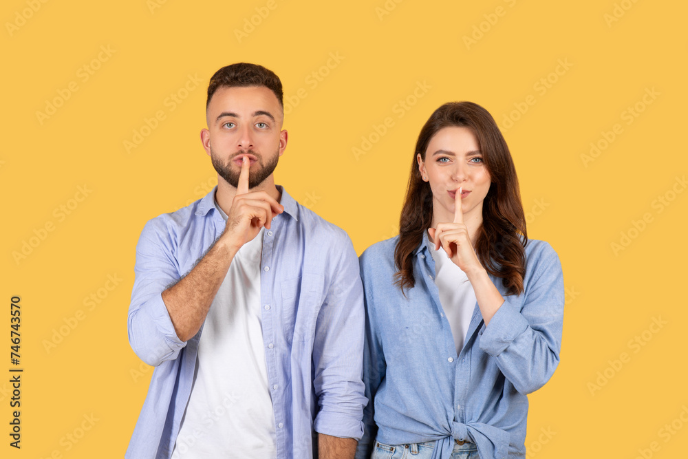 Quiet gesture, couple with fingers on lips Quiet gesture, couple with fingers on lips