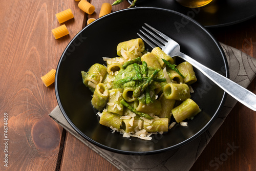Piatto di deliziosa pasta condita con pecorino e crema di asparagi selvatici, cibo italiano, ricetta vegetariana  photo