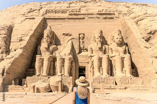A blonde haired woman with a hat stands in front of the Abu Simbel temple in Egypt, © Nick Brundle