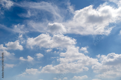 Blue sky with puffy cloud formations, natural background