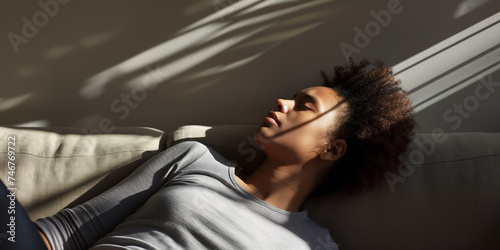 Lifestyle portrait of black woman napping on couch in sunlight