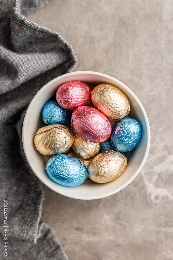Easter chocolate eggs wrapped in aluminium foil in bowl on kitchen table. Top view. Easter chocolate eggs wrapped in aluminium foil in bowl on kitchen table. Top view.