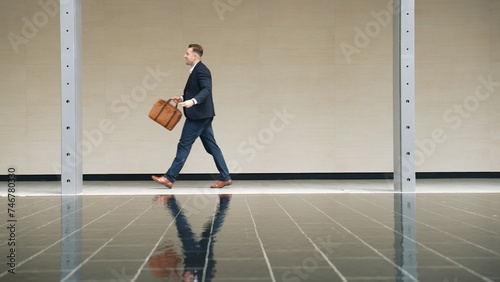 Side view of business people holding suitcase and walking to workplace along the street in urban city. Professional project manager going to meeting while wearing formal suit walk at outdoor. Urbane. © Summit Art Creations