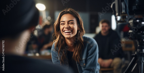 woman sitting in filmmaking studio smiling and speaking with video crew photo