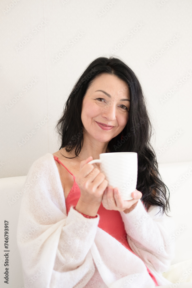 An isolated serene woman with black hair is enjoying a warm drink, embodying the calm acceptance of midlife hormonal changes, and menopause. An isolated serene woman with black hair is enjoying a warm drink, embodying the calm acceptance of midlife hormonal changes, and menopause.