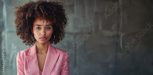A stylish professional in a modern pink pantsuit poses confidently, her demea...