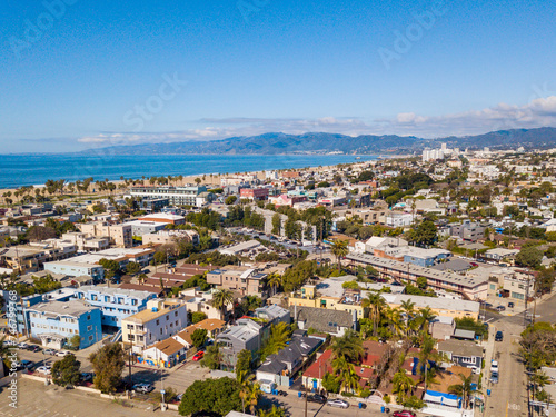 Aerial drone view over Venice looking towards the beach and the Santa Monica Mountains on a clear blue sky day. © Adam