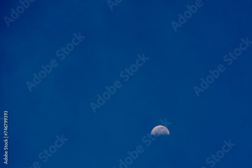 blue sky and half moon