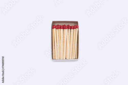 Matches in a matchbox. An open cardboard matchbox filled with matches on a white background. Top view of matches close-up with space for text