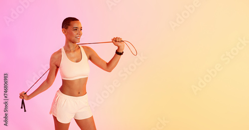 Smiling woman in activewear using a resistance band for her exercise routine
