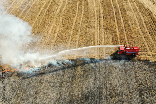 aerial view og Firetruck putting out fire in field