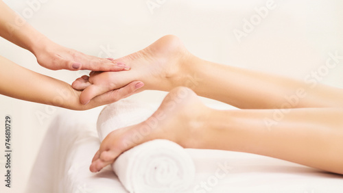Spa Concept. Masseur Massaging Female Feet Closeup