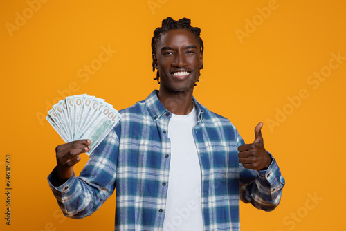 Great Profit. Black Man Holding Dollar Cash Money And Showing Thumb Up