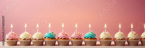 Colorful cupcakes with lit candles are displayed against a pink background  indicating an indoor celebration event marking of joy and celebrating. banner with free space