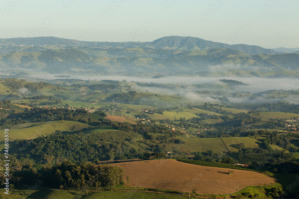 Obraz premium Serras cobertas com névoa, vegetação e céu azul. 