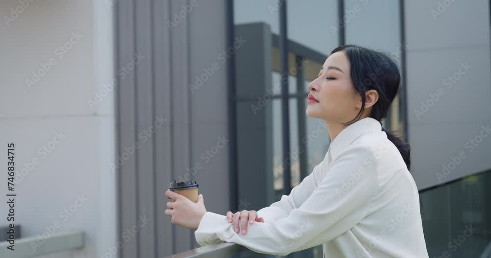 Thoughtful Asian businesswoman holding a coffee cup, looking into the distance outdoors near modern office buildings.
Thoughtful Asian businesswoman holding a coffee cup, looking into the distance outdoors near modern office buildings.