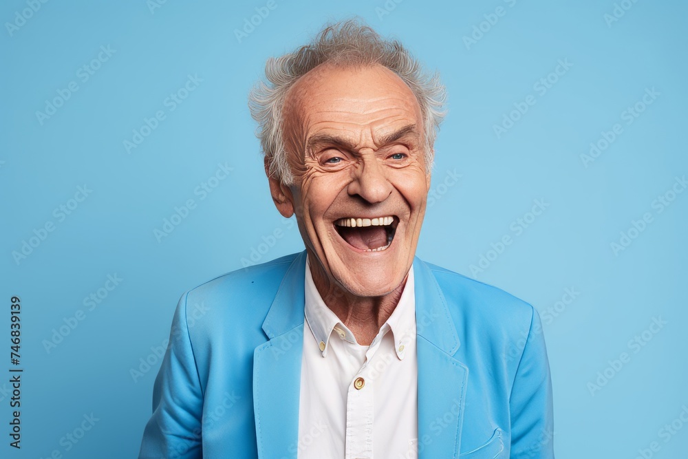 Portrait of happy senior man looking at camera and laughing, isolated on blue background Portrait of happy senior man looking at camera and laughing, isolated on blue background