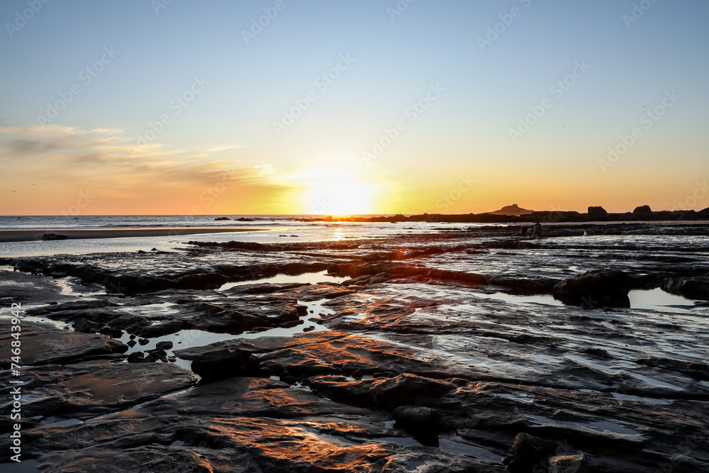 Sunset above rocks and tide pools on the Oregon Coast in Lincoln City at Roads End. Glistening water, rock formations and soft sunshine. Sunset above rocks and tide pools on the Oregon Coast in Lincoln City at Roads End. Glistening water, rock formations and soft sunshine.