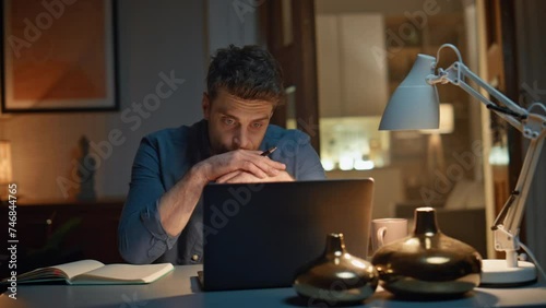 Guy speaking online meeting computer at night home closeup. Man video calling photo
