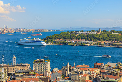  Galata Tower aerial view on Istanbul skyline featuring the bosphorus strait and a cruise ship on a clear sunny day in Turkey.