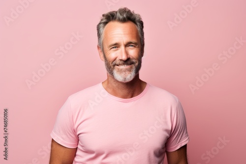 Handsome mature man in pink t-shirt. Studio shot.