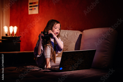 Canvas Print Intense focus is etched on a young girl's face as she maneuvers a game controlle