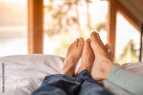 Closeup Couple's Feet Relaxing Resting In Bed at Home bedroom Enjoying Peaceful Quiet Weekend Day Off .Love and Happy relationships concept 