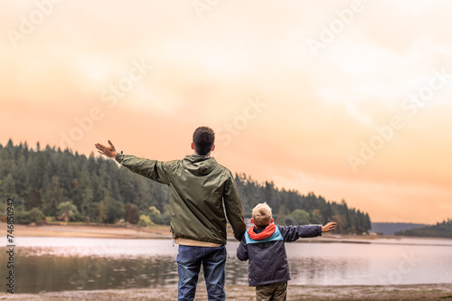 Happy Parent and Child Arms Up to the Sunset Sky 