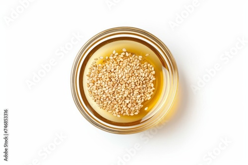 Top view of a glass bowl with isolated sesame oil on a white background