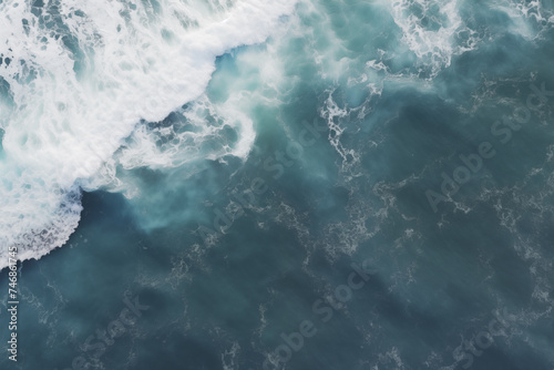 Drone aerial footage of electric blue ocean with wind waves crashing on the shore, a breathtaking aerial view