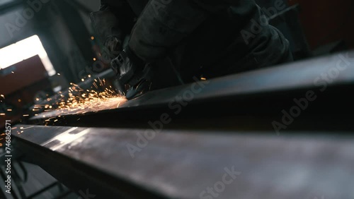 Arbeiter schleift den Stahlträger mit dem Winkelschelifer