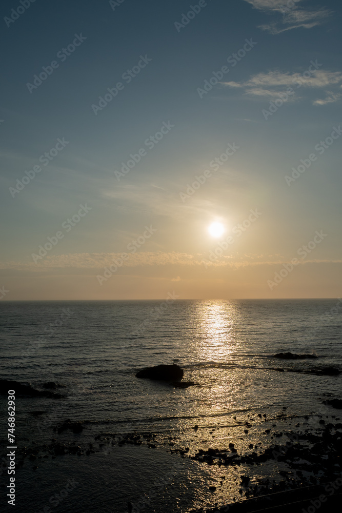 Obraz premium 夕日を反射してオレンジ色の輝く海 