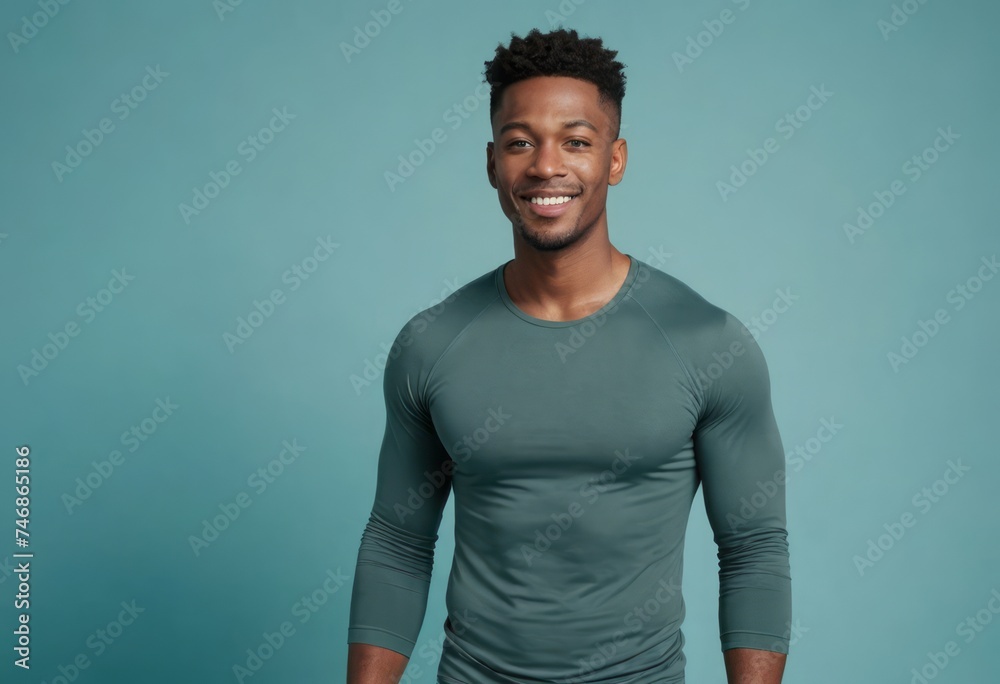 Obraz premium Muscular man in a fitted green tee, his broad smile and athletic build indicating a healthy, active lifestyle.