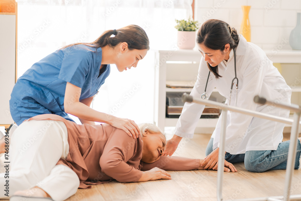 Fototapeta premium senior patient falling on the ground floor at home, Asian caregiver helping elderly older female from accident after doing physical therapy then rescued by attractive therapist nurse, health insurance