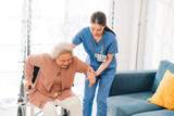 Elderly senior woman, asian woman doctor nursing home to helping take care to retirement patient who sitting on wheelchair, caregiver nurse support to medical health care insurance at home or hospital