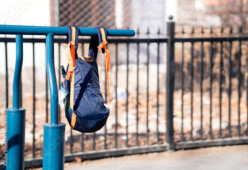 A book bag hanging from the parallel bars equipment photo